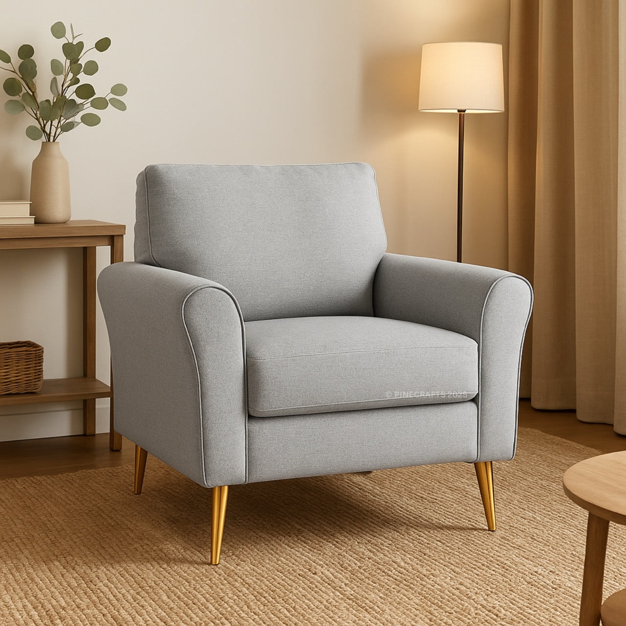 Gray armchair in a living room setting with a lamp and plant.
